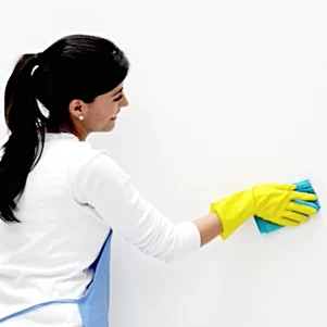 Cleaning expert from Capital Coastal Cleaning wiping a wall during an end-of-lease cleaning service in Canberra and Batemans Bay.
